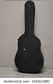 An Old Guitar Case Against A Wall