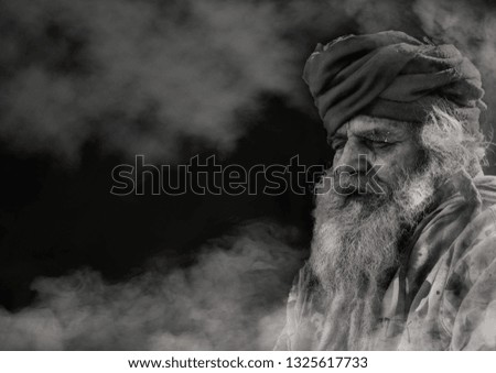 Old guru meditating on mountain fog