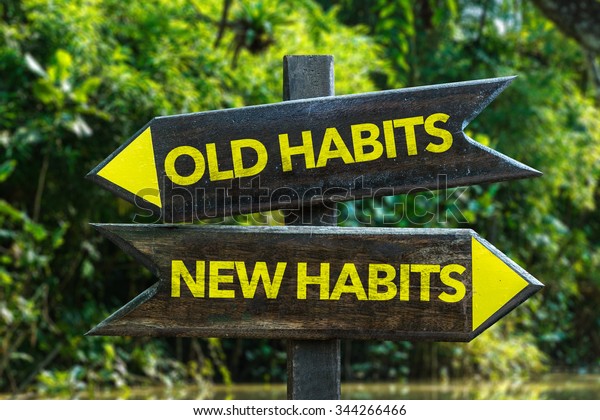 Old\
Habits - New Habits signpost with forest\
background