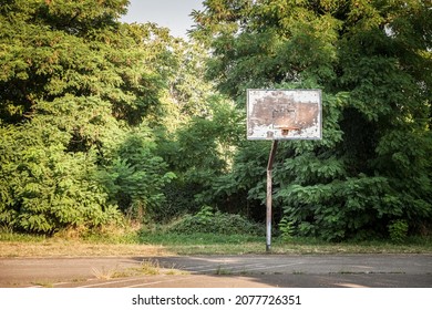 Old, half destroyed, rotten basketball backboard, in a decaying sports playground, standing during a cold winter.