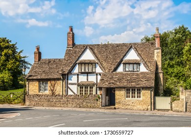 Old Half-timbered House With Multiple Chimneys Close  Road In To A Road In The Cotswolds UK