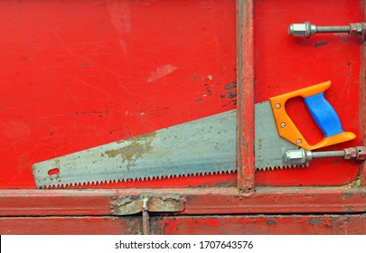 Old Hand Saw Is Attached To  Tailgate Truck Or Trailer. Body Side And Tool Teeth In Sawdust.