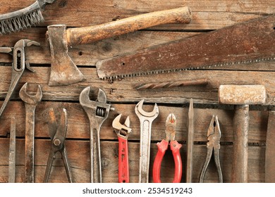 Old hand tool on a wooden surface. Tools for repair and construction, top view. Composition from an old rusty tool - Powered by Shutterstock