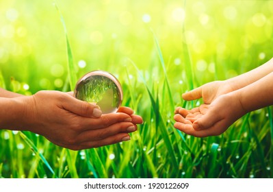 Old Hands holding glass green planet. Environmental protection for the new generation. Save Earth. Concept of the Environment World Earth Day.