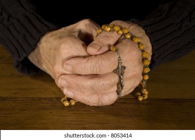 Old Hands Praying With Rosary