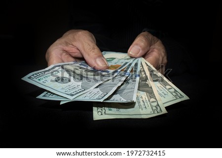 Old hands showing dollars in cash 