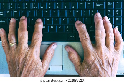 Old Hands Typing On The Computer Keyboard From Above.Selective Focus On The Hands 