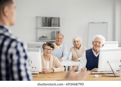 Old Happy People Listening To Their Teacher Talking About Technology