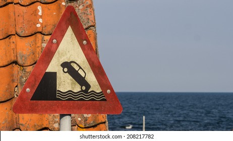 Old Harbor Sign Warning You Not To Drive Your Classic Car Over The Edge And Plunge Down Into The Water.  Can Be Used To Illustrate The Wall Street Crash Of 1929 Since The Car Depicted Is From That Era