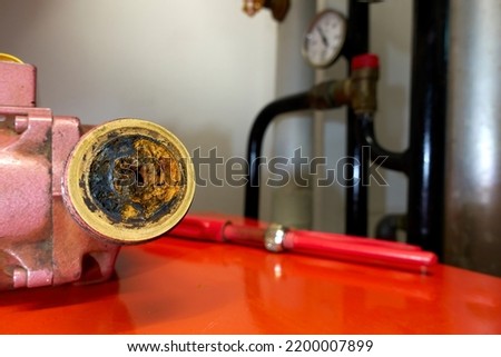Old heating pump with rust and lime. Inefficient installation element is renewed to save expensive electricity costs and energy.