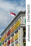 The Old Hill Street Police Station, built in 1934, features colorful shutters, colonial charm, and the Singaporean flag, blending heritage with vibrancy in one of Singapore’s iconic landmarks.