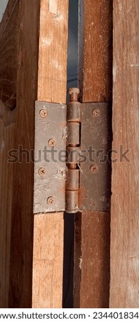 Old hinge on rusty door

