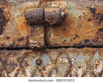 An old hinge withe rust and weathered paint.