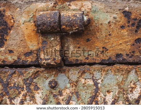 An old hinge withe rust and weathered paint.