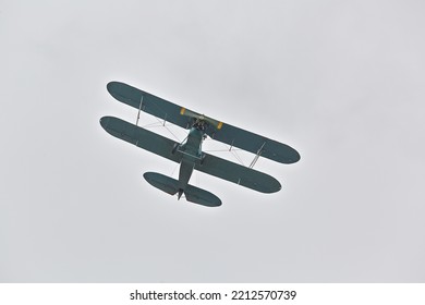 Old historic biplane aircraft in the sky flying