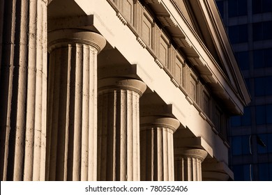 Old Historic Federal Style Architecture Capitol Courthouse Building with Columns Pillars Against Modern Skyscraper Buildings Early Morning Sunlight 