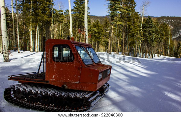 Old historic snow mobile\
or snow cat at a ski resort in Norther New Mexico USA near Santa Fe\
and Taos deep in the forest with Aspen and pine trees surrounding\
the slope
