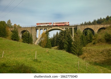 Old Historical Rail Viaduct Over The Valley In The Mountains With Passing Regional Train On It, Slovakia