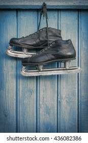 Old Hockey Skates Hanging On A Blue Wooden Wall