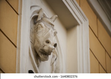 Old horse head sculpture made of stone at entrance of a house
