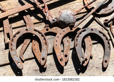 Old horseshoes and tools of work of a blacksmith on wooden boards. - Powered by Shutterstock