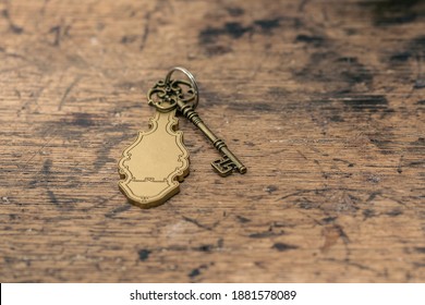 Old Hotel Key With A Vintage Keychain Mockup. Key Laying On Chabby Wooden Table, Or A Reception Desk.