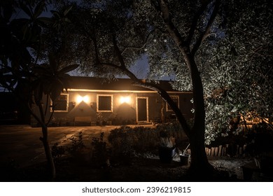 Old house with a Ghost in the forest at night or Abandoned Haunted Horror House in fog. Old mystic building in dead tree forest. Trees at night with moon. Surreal lights. Horror Halloween concept - Powered by Shutterstock