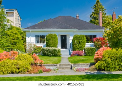 Old house with nicely trimmed and landscaped front yard in the suburbs of Vancouver, Canada.