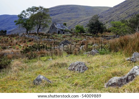 old house sits among rocks and mountains in The Black Valley, Co.Kerry, Ireland