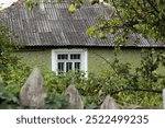 old house with a slate roof with an old wooden fence and an old pear tree