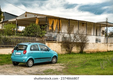 Old house and a small car parked outside