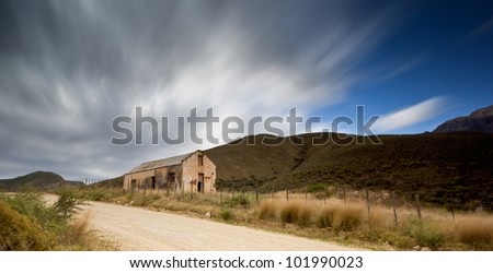 old house with streaky clouds