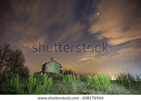 Old house under a bright night sky filled with stars