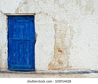 old house white wall with blue door