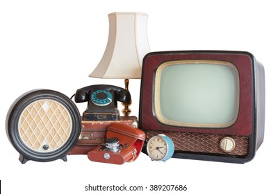 Old household items: TV, radio, camera, alarm, phone, table lamp, suitcase.   Old household items isolated on white background. 