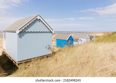 Old Hunstanton, Norfolk, UK - July 21st 2022:A Line Of Pastel-coloured Wooden Beach Huts In Marram Grass Covered Sand Dunes By The Sea On The East Coast Of England.