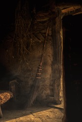 Old Hut With A Floor Of Mud, A Ray Of Light Enters The Room Through An Open Door. Next To The Door There Is An Old Fashioned Broom That Could Be A Witches Broomstick