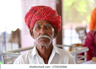 Old Indian Man In Long White Mustache And Wearing Red Turban Suffering From Eye Problem. Cataract In Eye. Loss Of Vision. Damaged One Eye. Eye Disease. 