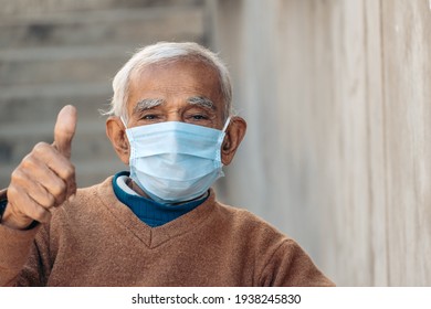 Old Indian man wearing mask giving thumbs up after vaccination. New strain of corona virus in India 2021. - Powered by Shutterstock