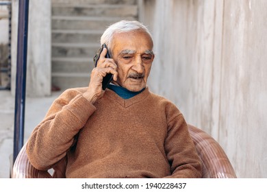 Old Indian senior man talking on phone. Mature successful businessman using mobile phone