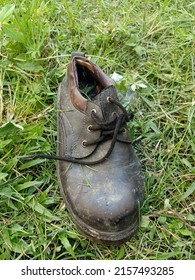 Old Industrial Factory: A Singgle Old Work Boots On The Grass