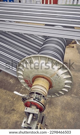 An Old industrial stainless steel metal cotton weaving spindle reel, machine weaving Burberry cotton for the fashion and textiles industry. Yarn weave traditional textile fabric manufacturing
