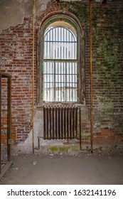 Old Industrial Warehouse Window With Jail Bars And Exposed Brick Wall