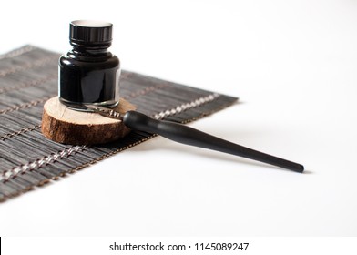 Old ink pen and ink bottle isolated on white background. Vintage calligraphy pen and bottle of ink. Selective focus. Close up. - Powered by Shutterstock