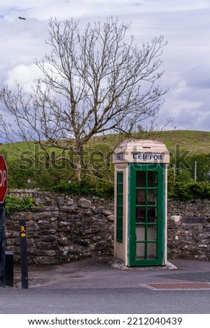 Old Irish phone booth, public payphone in ireland with Gaelic lettering 