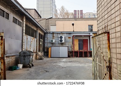 Old Iron Gate To The Warehouse. Abandoned Industrial Building Exterior