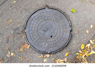 Old iron manhole cover on the street sewer cap front view