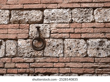 Old Iron Ring Set on Ancient Brick Wall; Sienna, Italy.