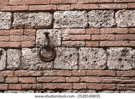 Old Iron Ring Set on Ancient Brick Wall; Sienna, Italy.