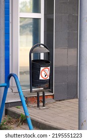 Old Iron Urn For Garbage, Sign Warning Not To Throw Burning Cigarette Butts Inside, Close-up Against Wall Of Building In Vertical Format